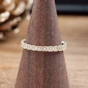 Hazel Eternity Ring with natural white diamonds set in solid gold on a wooden ring display cone