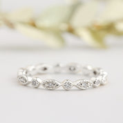 Close-up of an art-deco inspired petite eternity ring with natural white diamonds and milgrain detailing in solid gold