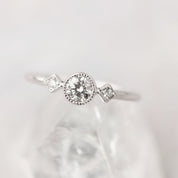 Close-up of a moon and star ring with a brilliant-cut diamond and milgrain bezel setting on a delicate band