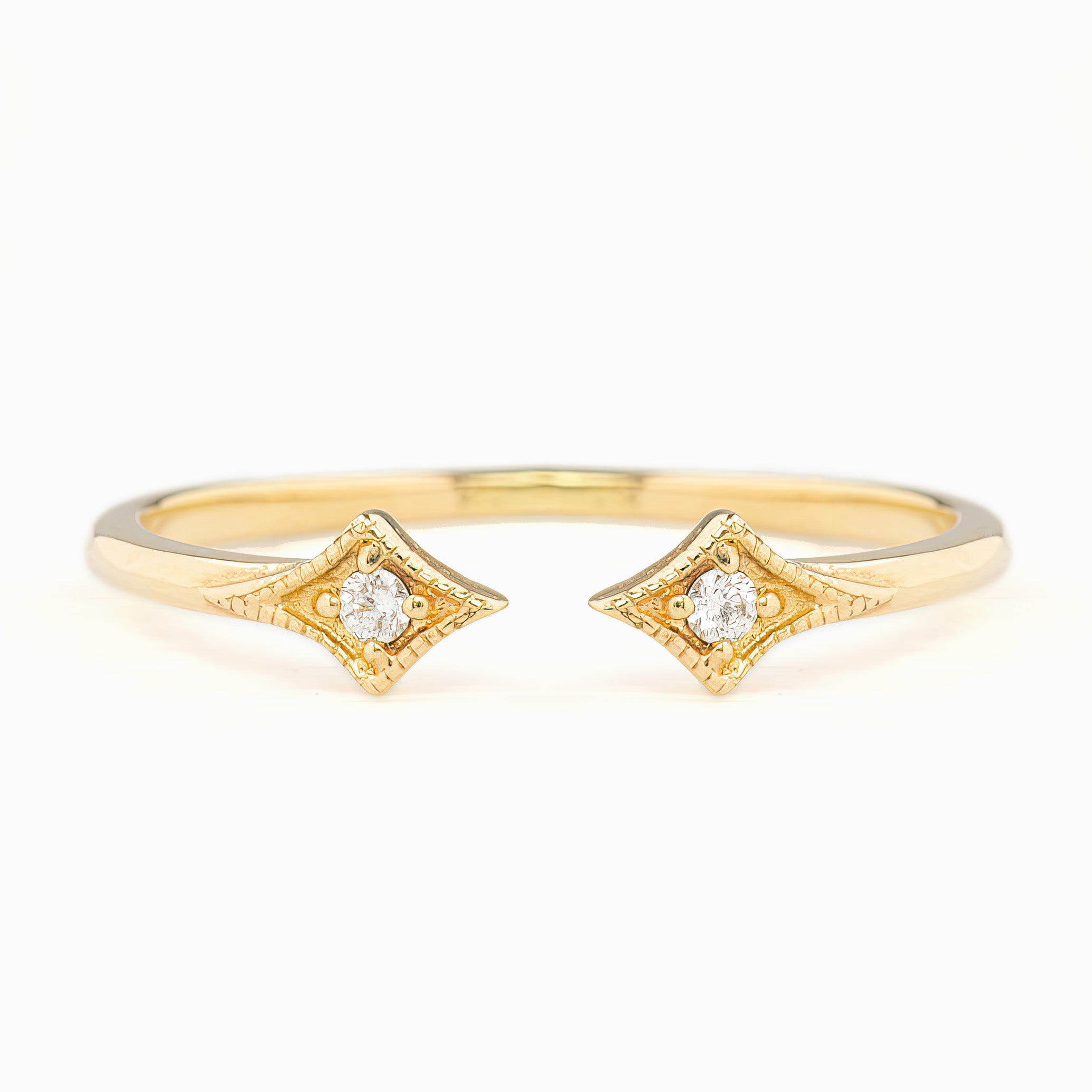 Delicate open gold ring with two star-shaped settings each holding a small brilliant cut white diamond