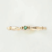 Delicate 14k yellow gold ring with a small green gemstone, featuring a thin 1.75mm recycled metal band design.