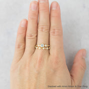 Close-up of hand wearing a Six Star Ring with natural white diamonds and solid gold band on finger