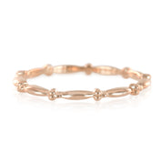 Rose gold beaded stacking ring with delicate rounded and elongated beads forming a continuous pattern.