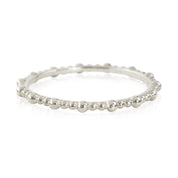 Close-up of a Gemma full eternity bead ring in solid gold with a delicate 1.5mm band, ethically sourced and unresizable.
