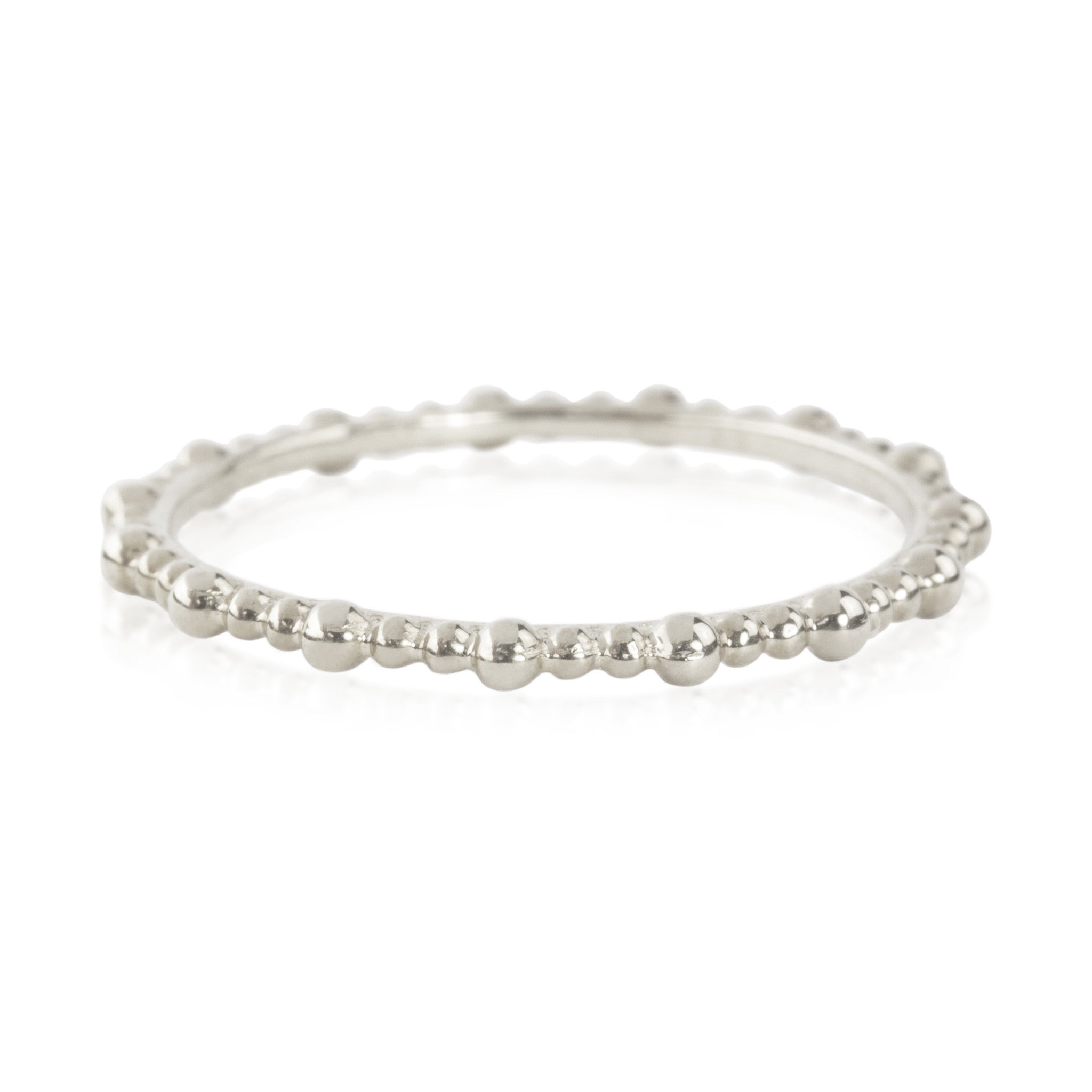 Close-up of a Gemma full eternity bead ring in solid gold with a delicate 1.5mm band, ethically sourced and unresizable.