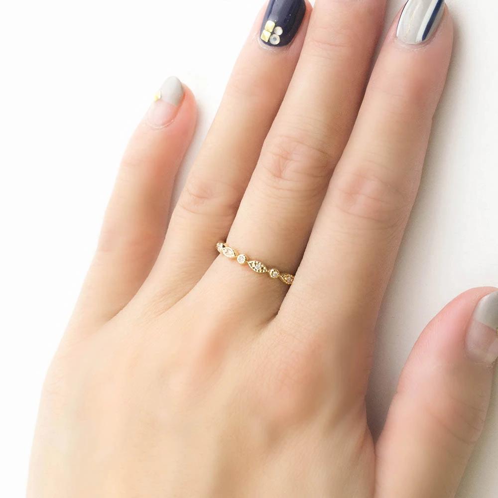 Tia Petite Half & Full Eternity Ring in gold with milgrain detail and natural white diamonds on a hand.