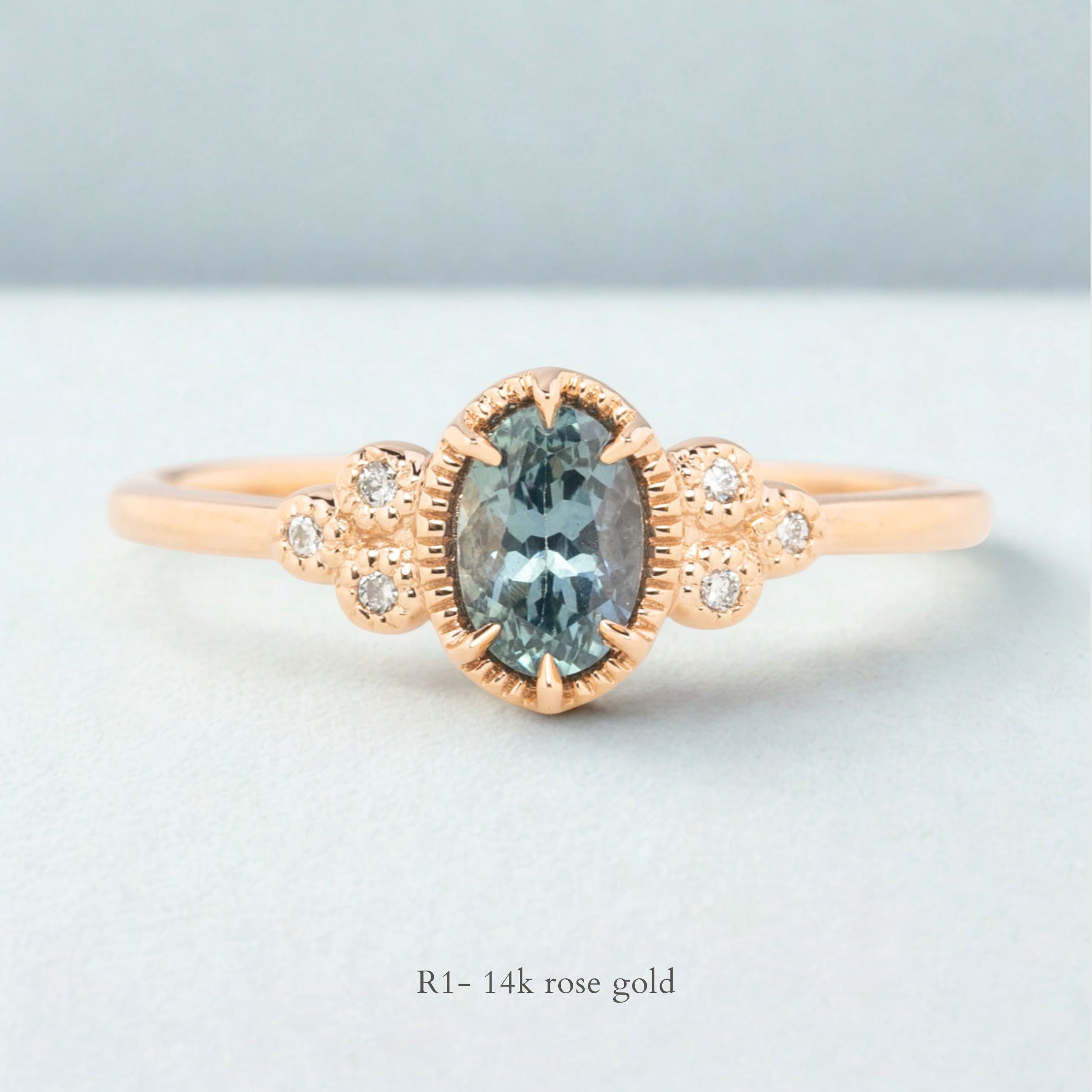 Celine Ring featuring a 0.60ct teal-blue Montana sapphire in a 14k rose gold with six natural diamond accents