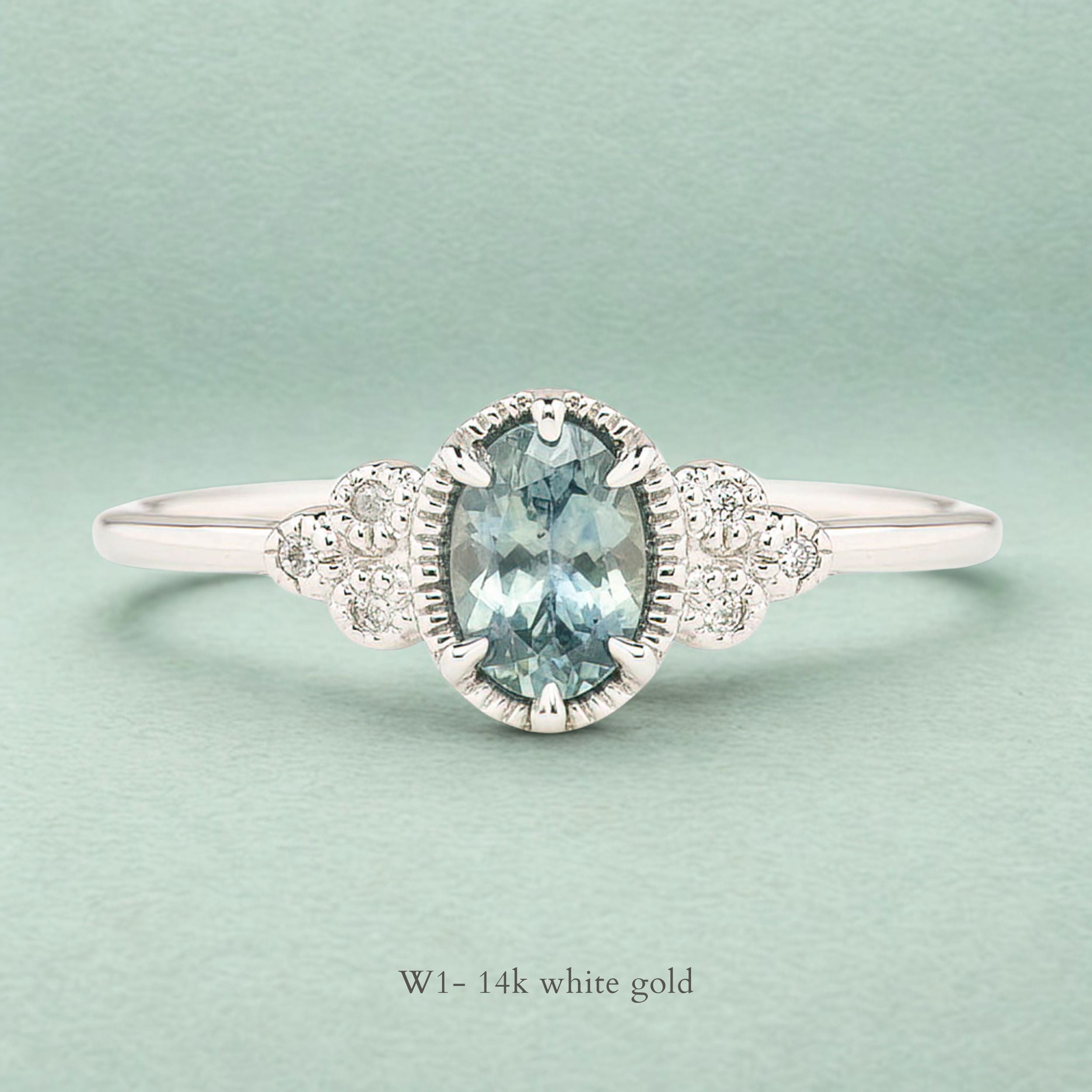 Celine Ring featuring a 0.60ct teal-blue Montana sapphire in a 14k white gold with six natural diamond accents