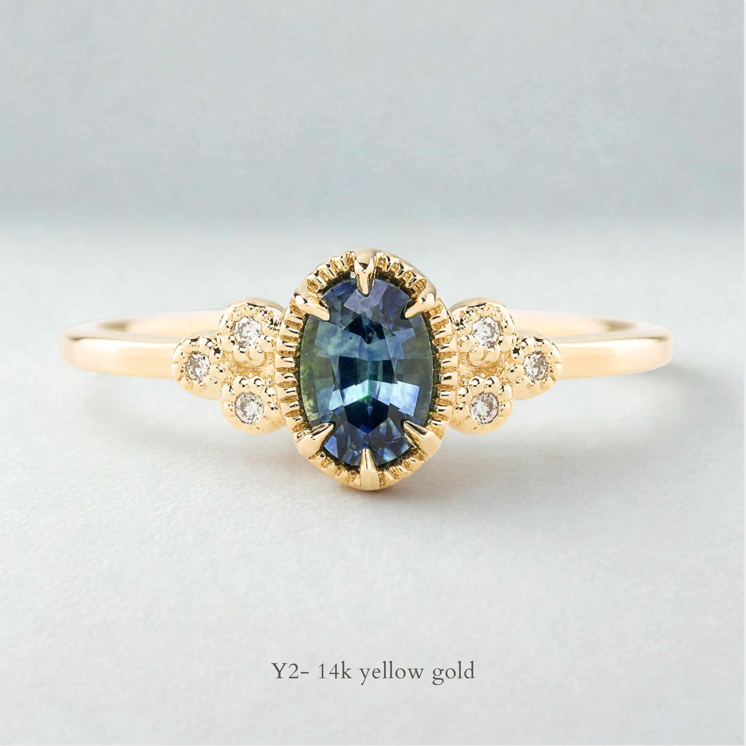 Celine Ring featuring a 0.60ct teal-blue Montana sapphire in a 14k yellow gold with six natural diamond accents