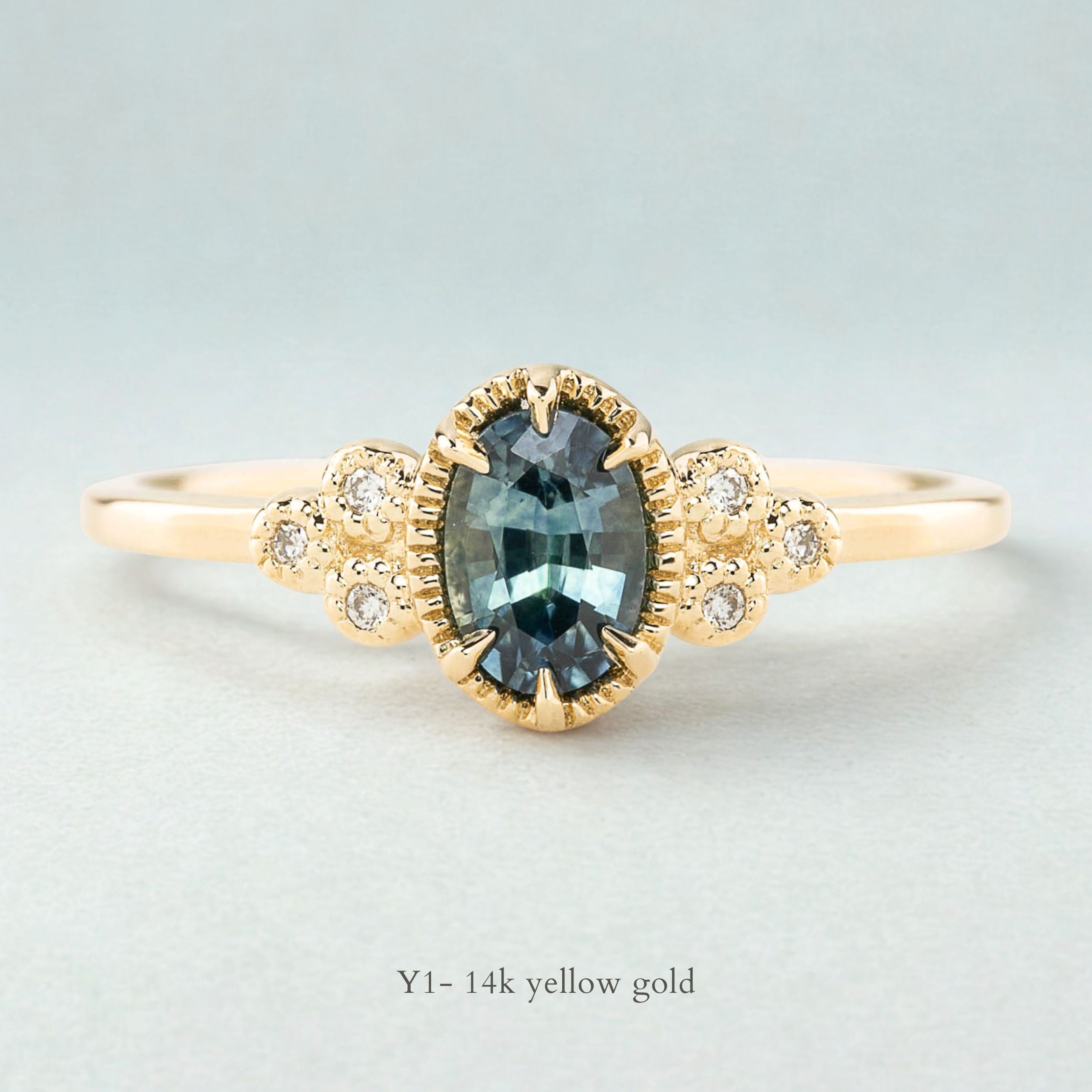 Celine Ring featuring a 0.60ct teal-blue Montana sapphire in a 14k yellow gold with six natural diamond accents