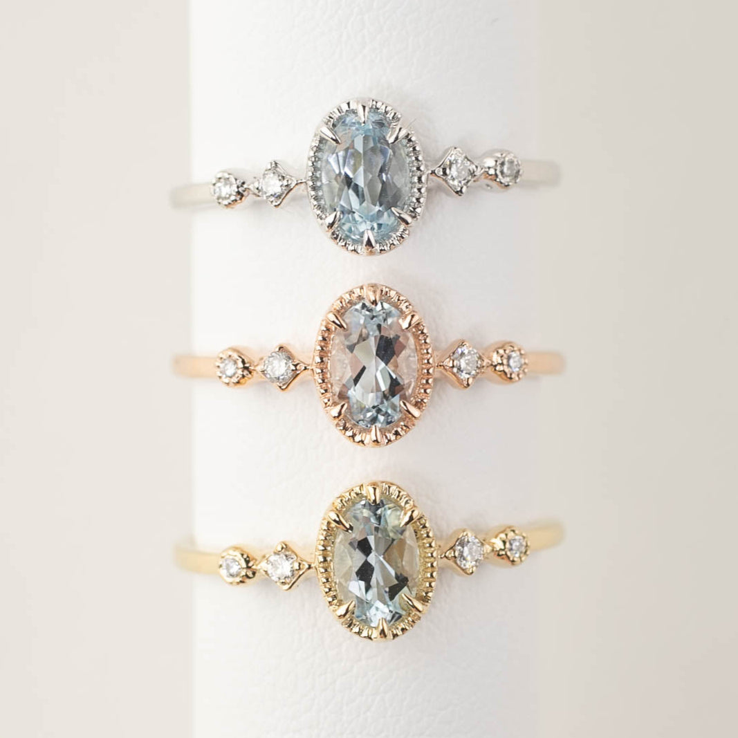 Three gold rings with aquamarine gemstones on a white background