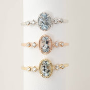 Three gold rings with aquamarine gemstones on a white background