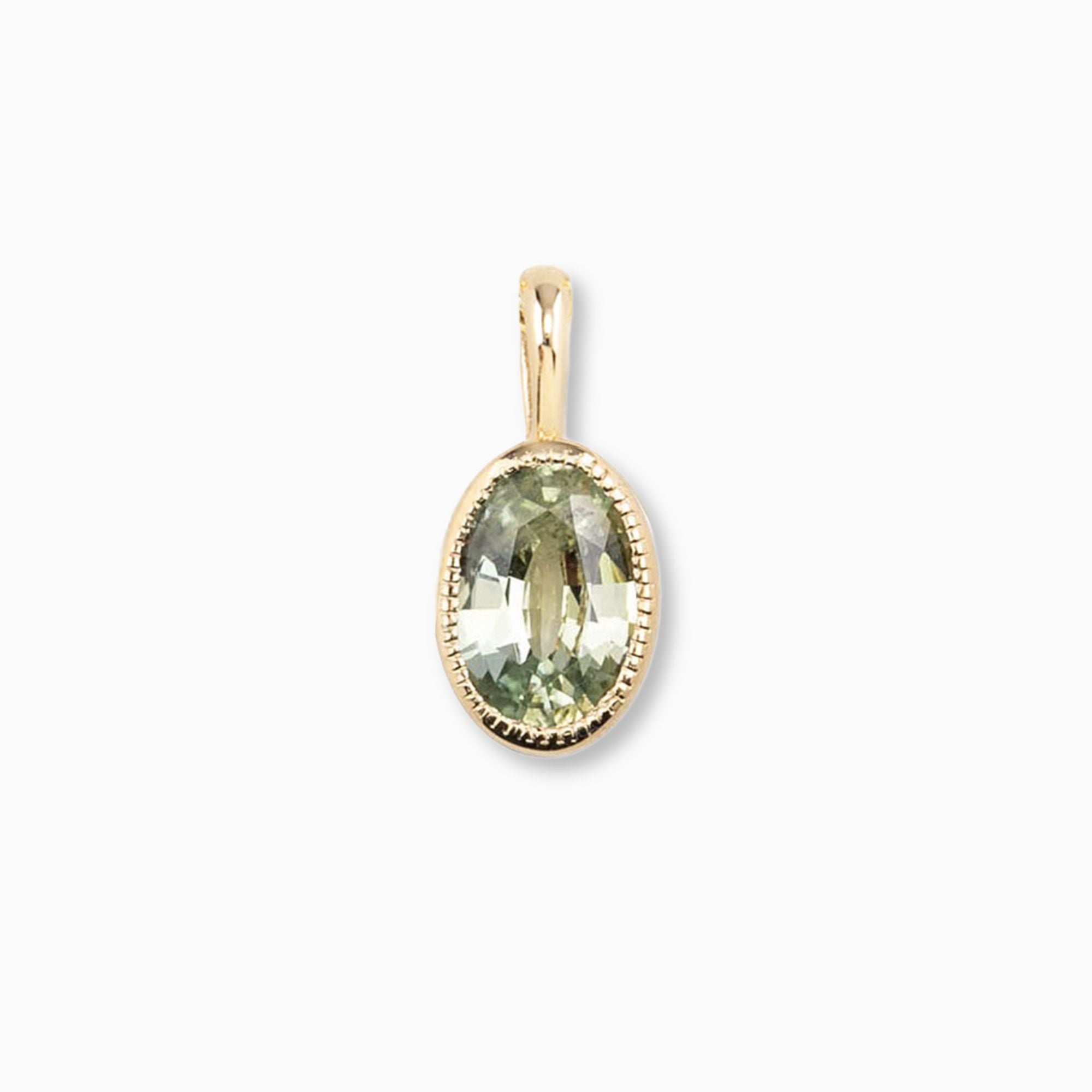 Gold pendant with a green gemstone on a white background