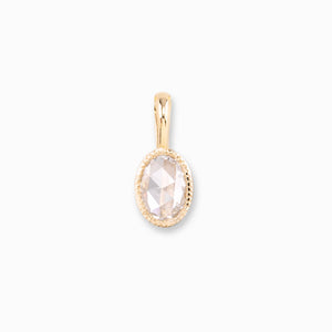 Gold pendant with a clear gemstone on a white background