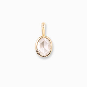 Gold pendant with a clear gemstone on a white background