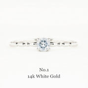 14k white gold ring with a diamond on a white background
