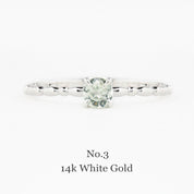 14k white gold ring with a green gemstone on a white background