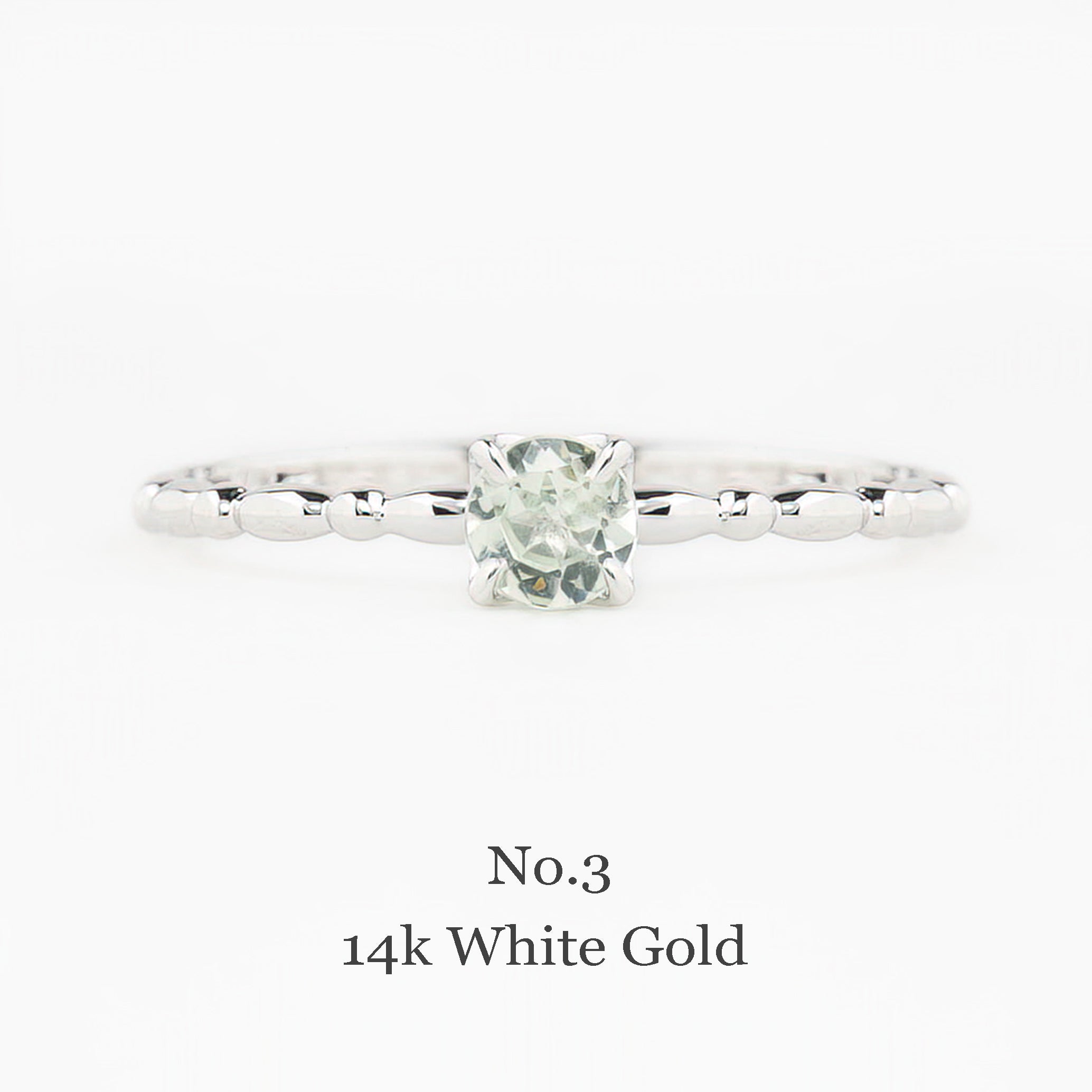 14k white gold ring with a green gemstone on a white background