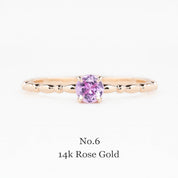 Rose gold ring with a pink gemstone on a white background