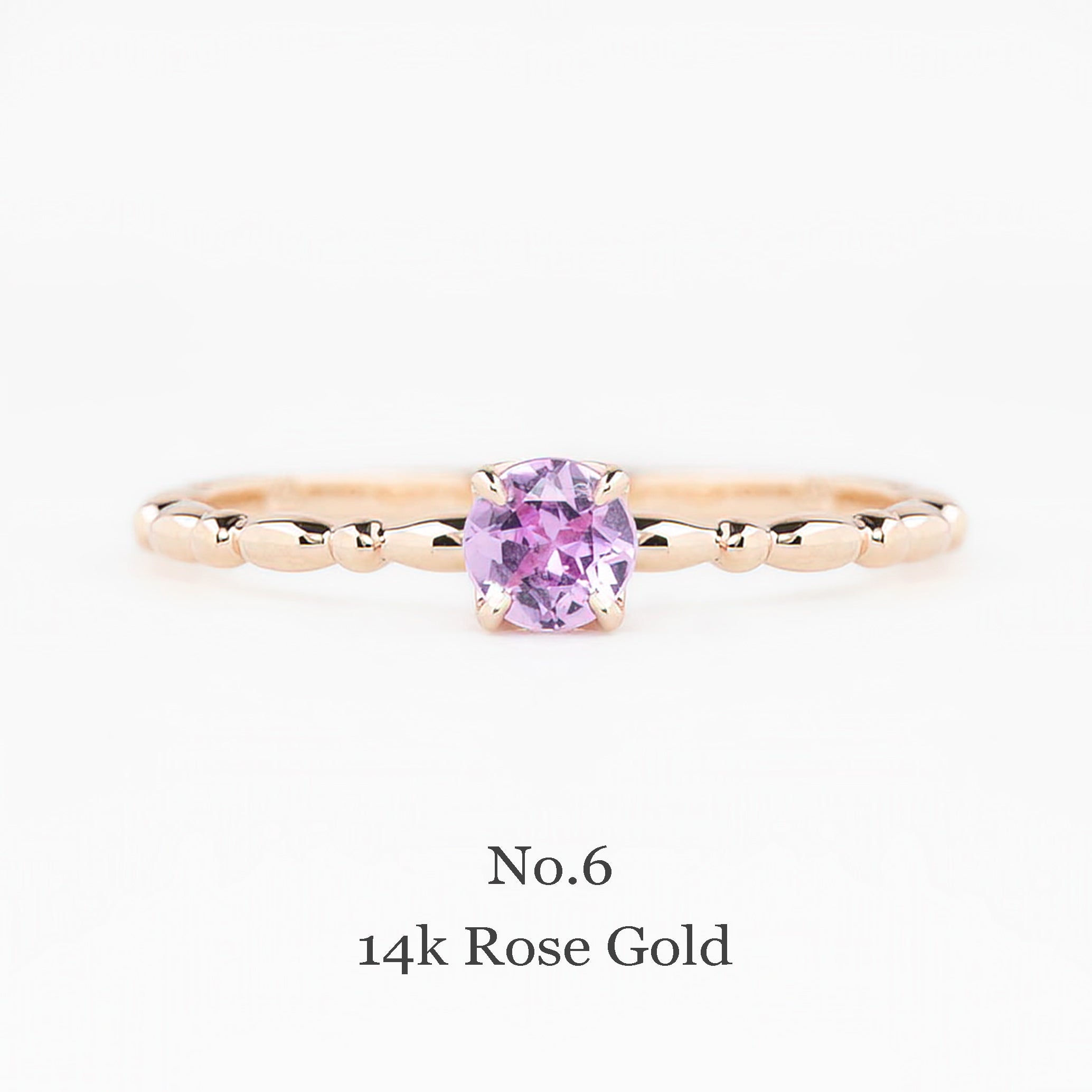 Rose gold ring with a pink gemstone on a white background