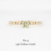 Gold ring with a green gemstone on a white background