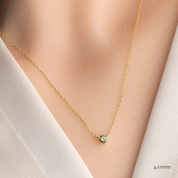Gold necklace with a green round 4.0mm sapphire 3 prongs pendant on a model