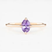 Ring with a purple gemstone on a white background
