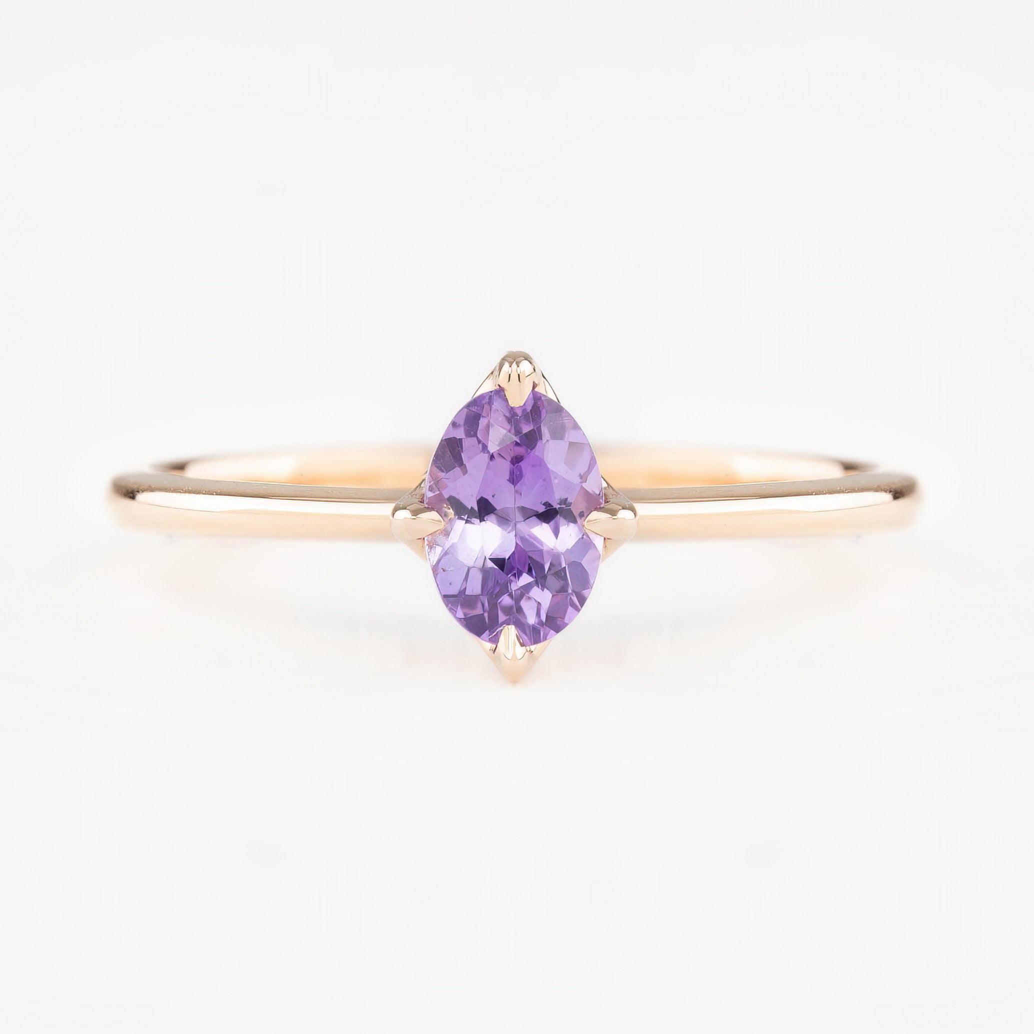 Ring with a purple gemstone on a white background