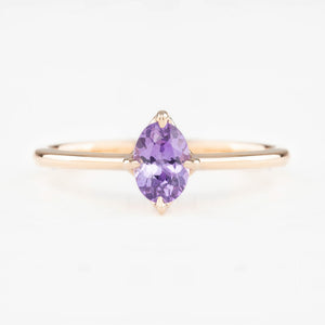 Ring with a purple gemstone on a white background