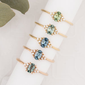 Set of gold rings with green gemstones on a white surface