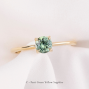 Gold ring with a green gemstone on a white background