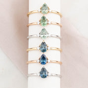 Six 14k gold ring featuring a Montana pear-cut sapphire with natural accent diamonds.