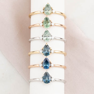 Six 14k gold ring featuring a Montana pear-cut sapphire with natural accent diamonds.