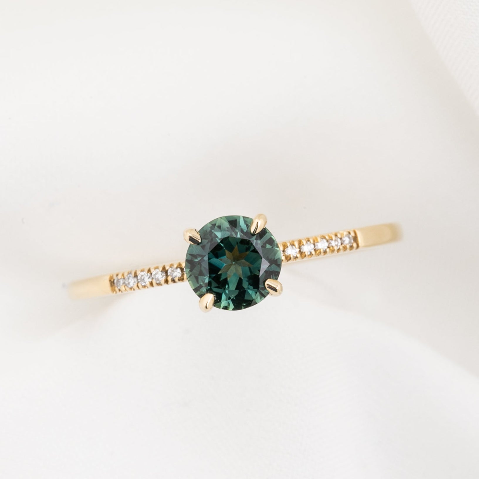 Audrey Ring, 0.73ct Queensland Sapphire with a green gemstone on a white background