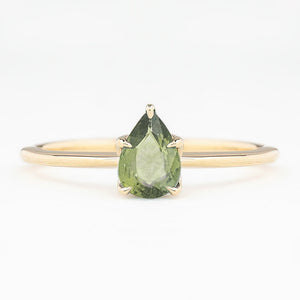 Gold ring with pear-shaped unheated green sapphire in a five-prong setting on a slim band