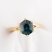 Gold ring with a green gemstone on a white background