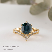 Gold ring with a hexagon shape green gemstone on a light background stacked with diamond curved ring