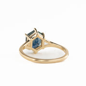 Gold ring with a blue gemstone on a white background - back view