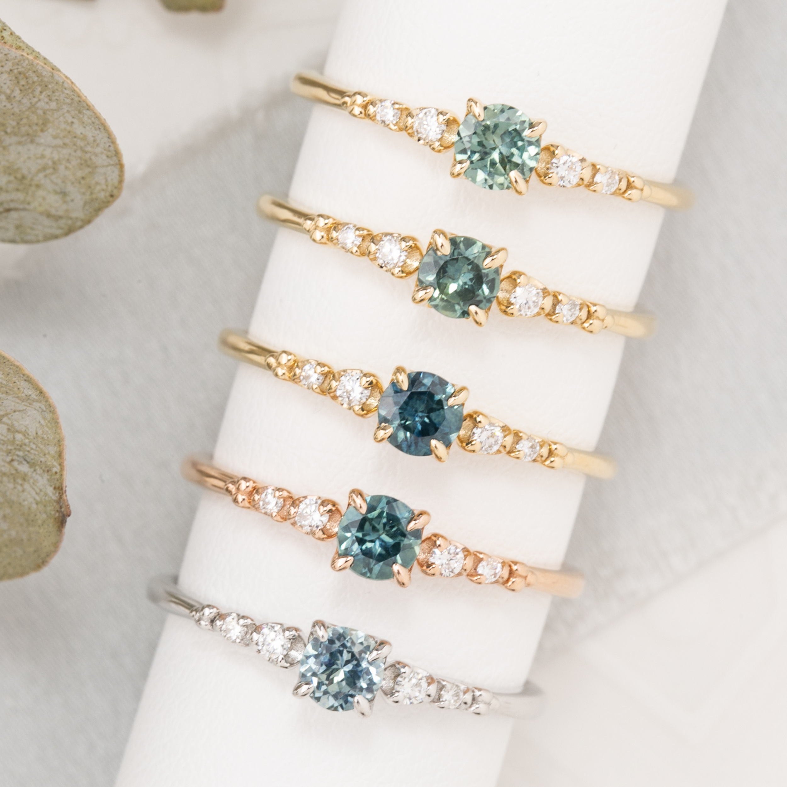 Six unique Estel Fleur rings featuring 0.40ct Montana sapphires in yellow, rose, and white gold.