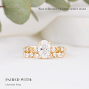 Gold ring with a central diamond and smaller diamonds on a light background