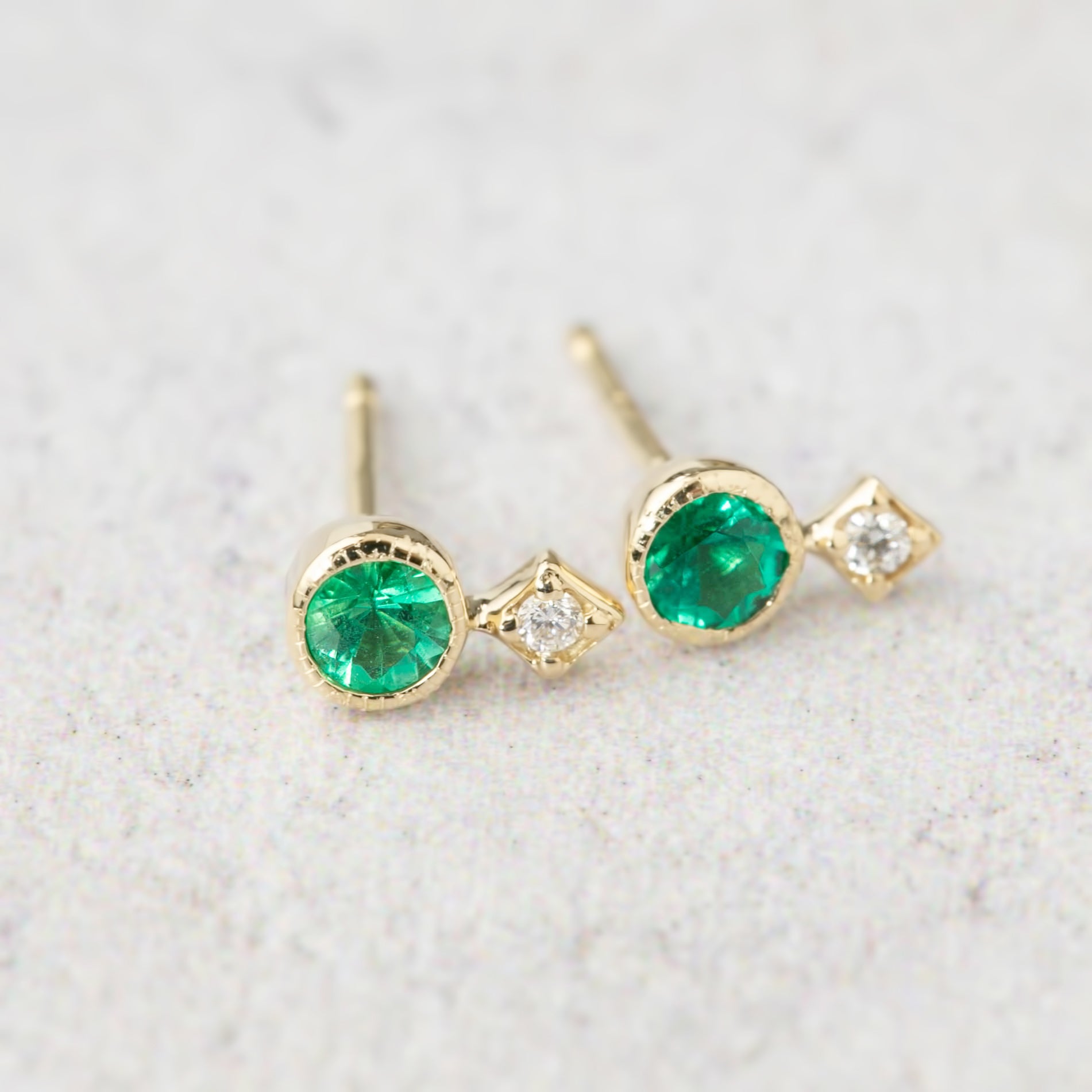 14K yellow gold stud earrings with round green gemstones and natural diamond accents