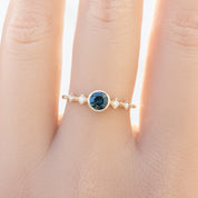 0.50ct teal blue Queensland Sapphire Ring in 14k yellow gold on finger