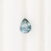 1.41ct pear-shaped Montana sapphire in blue green with medium teal saturation and precise cut on white background