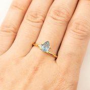 1.41ct pear-shaped Montana sapphire ring in gold setting on finger with medium teal blue color