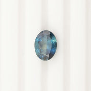 1.62ct oval cut teal blue Montana sapphire gemstone with eye-clean clarity and small inclusions visible under magnification