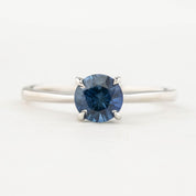 A round cut blue Montana Sapphire ring with a high prong setting, made of 14k white gold, size 7.