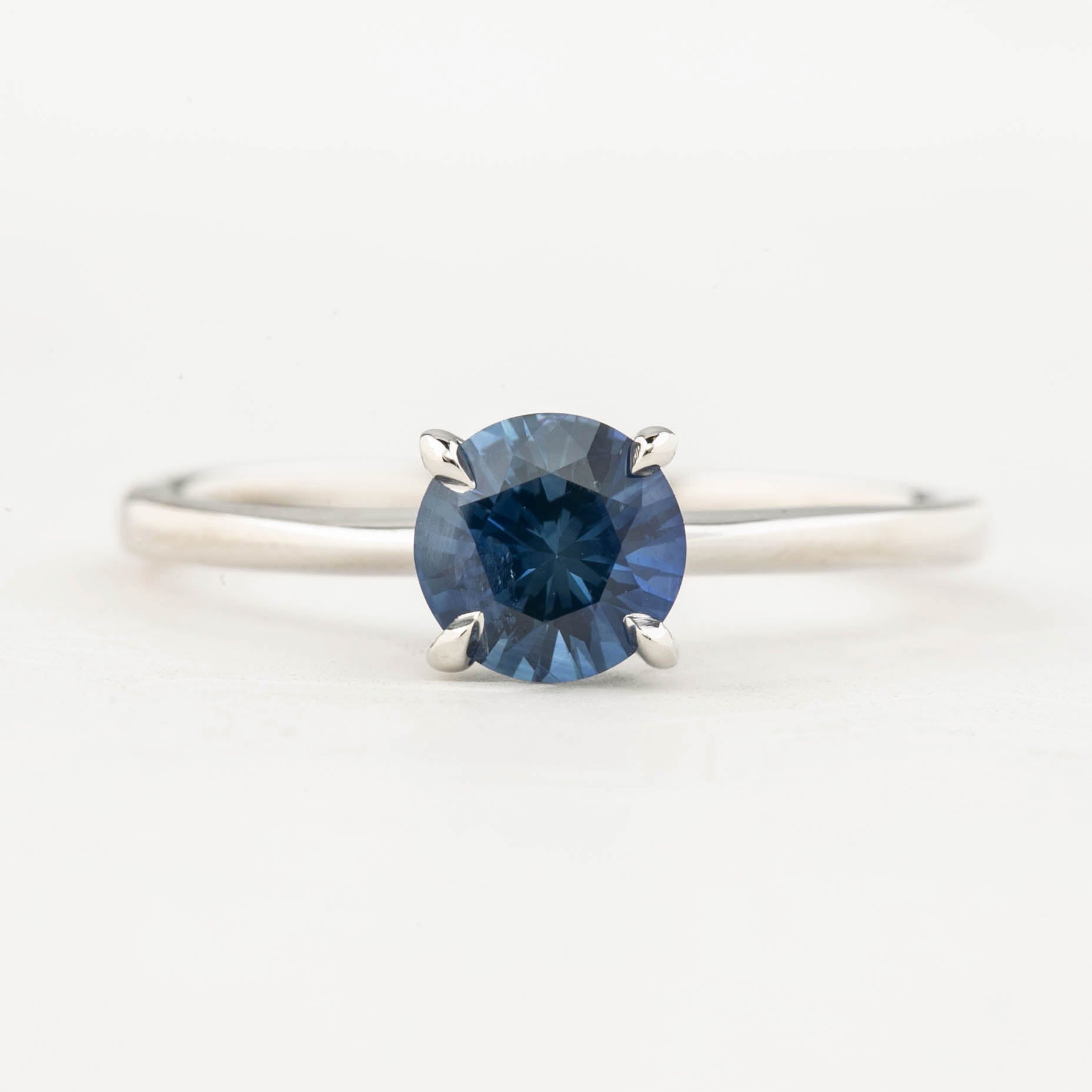 A round cut blue Montana Sapphire ring with a high prong setting, made of 14k white gold, size 7.