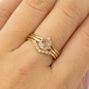 Close-up of a hand wearing a 0.88ct white sapphire Lisa Ring set in recycled 14k gold with small accent diamonds.