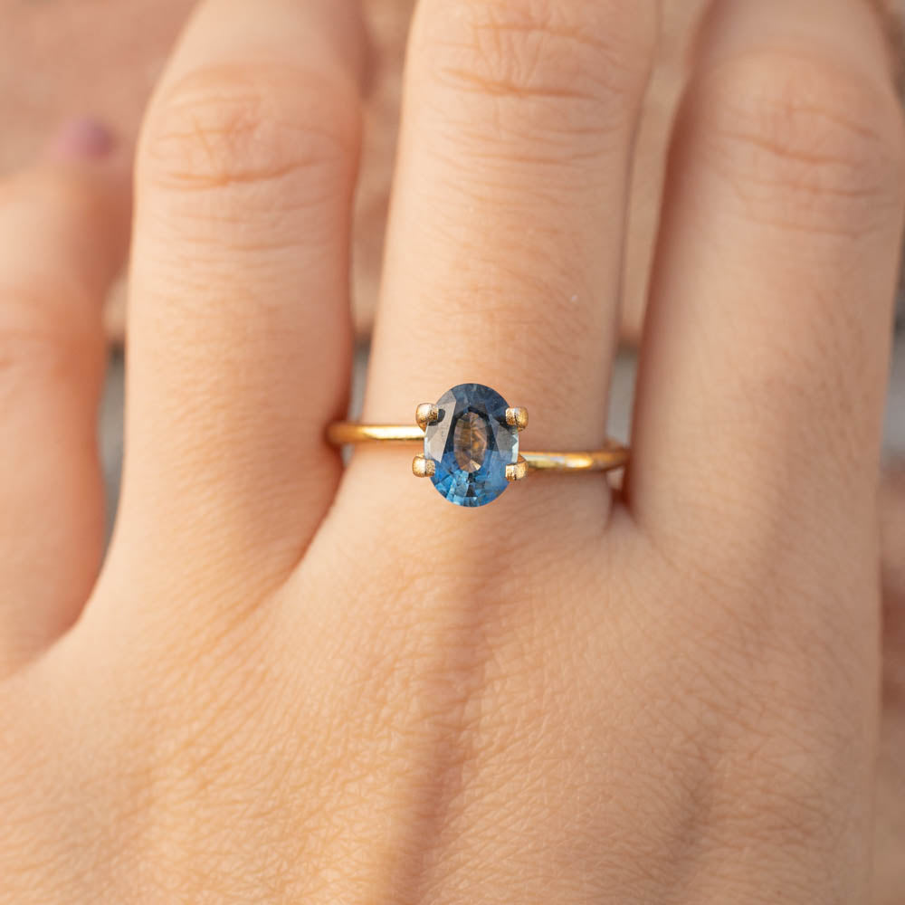 1.39ct Oval Cut Teal Blue Montana Sapphire ring with gold band, authentic and ethically sourced from Montana USA.