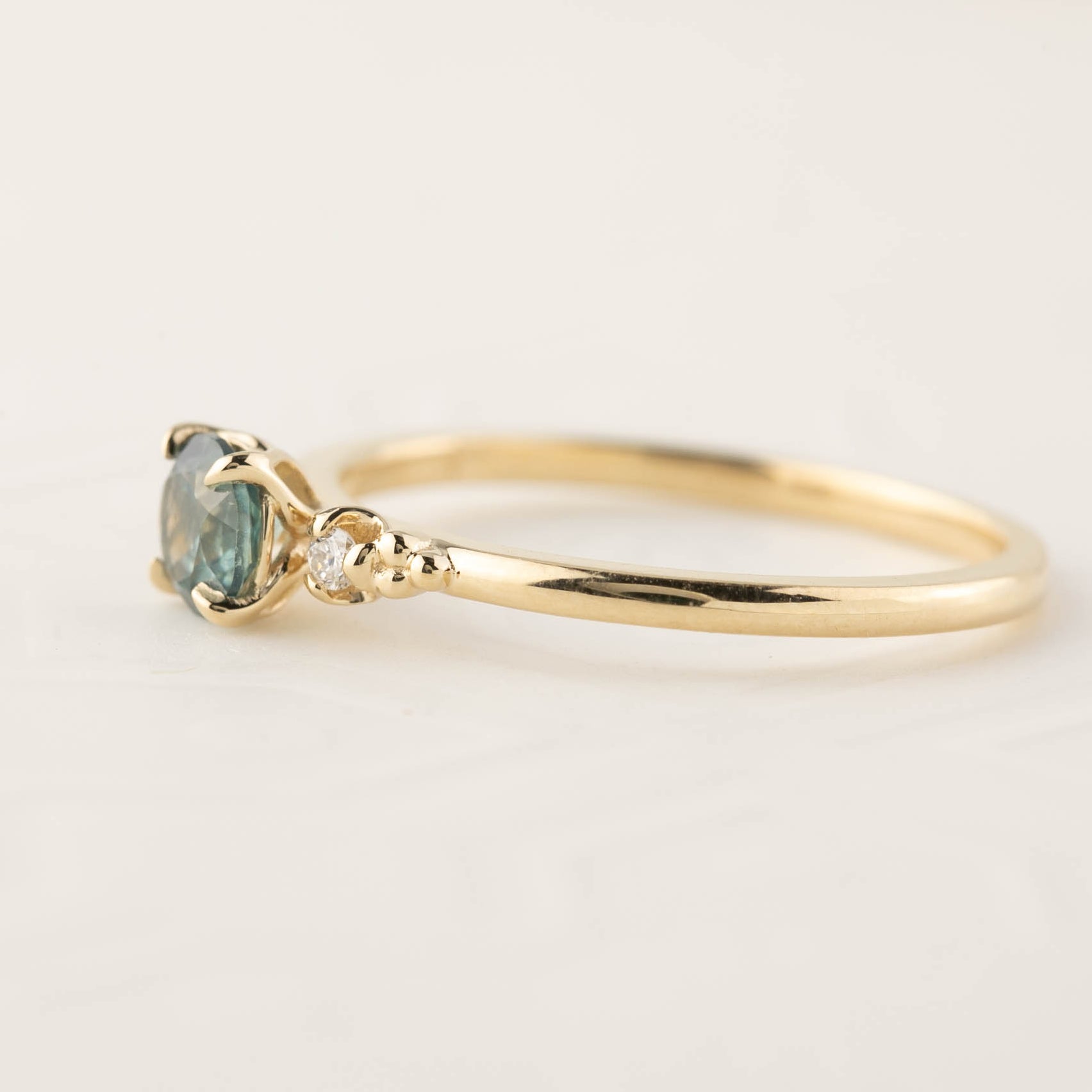 14k yellow gold ring with 4.5mm green Montana sapphire and small natural accent diamonds in flower setting